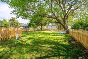 a yard with a tree and a hammock at The Mane Escape in Chincoteague