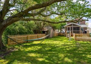 a yard with a fence and a hammock under a tree at The Mane Escape in Chincoteague