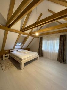 ein Schlafzimmer mit einem Bett auf einem Dachboden in der Unterkunft Pensiunea Carmen 1927 in Moieciu de Jos