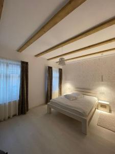 ein Schlafzimmer mit einem Bett und einem großen Fenster in der Unterkunft Pensiunea Carmen 1927 in Moieciu de Jos