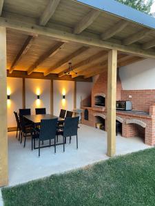 eine Terrasse mit einem Tisch, Stühlen und einem Kamin in der Unterkunft Pensiunea Carmen 1927 in Moieciu de Jos + 26 Fotos