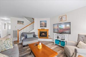 a living room with a fireplace and a tv at Whispering Pines in Black Point Landing