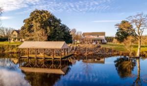un lac avec un kiosque et une maison dans l'établissement Casa Del Rio, à Pocomoke City