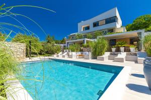 a villa with a swimming pool and a house at Oliveto Residence Bungalows - Adults only in Punat