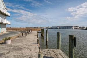 a wooden dock next to a body of water at Ducks, Docks, And Flip Flops in Chincoteague