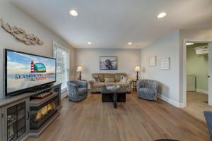 a living room with a flat screen tv and a couch at Eventide in Black Point Landing