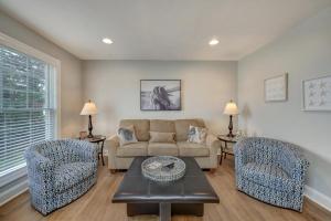 a living room with a couch and two chairs at Eventide in Black Point Landing +32 photos