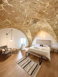 a bedroom with a bed and a stone ceiling at Kàllistos Suites & Apartments in Gallipoli