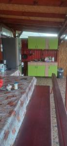 une grande cuisine avec des armoires vertes et une grande table dans l'établissement Casa Ștefania, à Pescari 14 autres photos