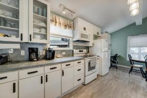 une cuisine avec des armoires blanches et un réfrigérateur blanc dans l'établissement Oyster Bay Oasis, à Deep Hole 31 autres photos