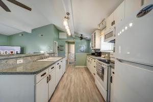 - une grande cuisine avec des appareils blancs et des murs verts dans l'établissement Oyster Bay Oasis, à Deep Hole