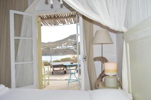 a bedroom with a bed and a view of the ocean at Sea Side Studios & Houses in Kalo Livadi