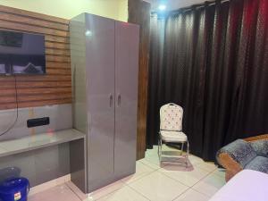a room with a chair and a glass cabinet at Hotel bless inn in Bankipur