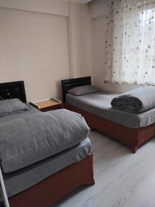 two twin beds in a room with a window at Ünye Kavaklar Holiday Houses in Unye