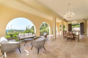 a living room with a couch and tables and chairs at Authentische Finca mit Pool & Traumblick auf Mallorca in Puigpunyent
