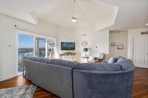 a large blue couch in a living room with a window at Sunset Bay Villa 313 - By The Bay in Chincoteague