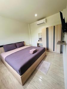 1 dormitorio con 1 cama grande con sábanas moradas en Fran Sim Da Guest House, en Bang Tao Beach