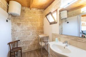 a bathroom with a sink and a mirror and a chair at Monolocale Emy - Salento Reservation in Il Monte +17 photos