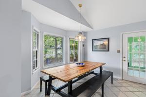 a dining room with a wooden table and windows at 36 Rabbit Run Lane in Ocean Pines