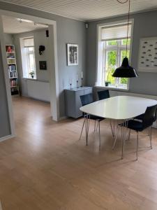 a dining room with a white table and chairs at Charmerende byhus - tæt på alt! in Svendborg +6 photos