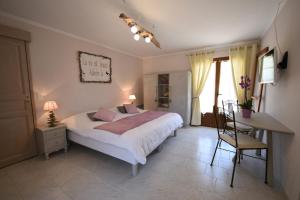 a bedroom with a bed and a table and a desk at Résidence Les Mandiles in Cargèse