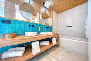 a bathroom with two sinks and a tub at HOVIMA Suites Costa Adeje in Adeje