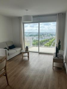 a living room with a couch and a large window at Résidence de Brest Lambézellec in Brest
