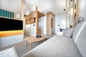 a living room with a couch and a tv at HOVIMA Suites Costa Adeje in Adeje