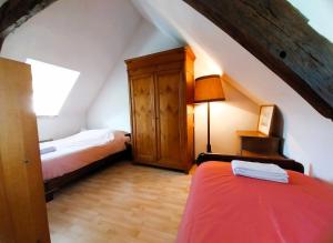 a attic room with two beds and a cabinet at Maison du GR34 Baie de Beaussais Classée 1 étoile in Beaussais sur Mer