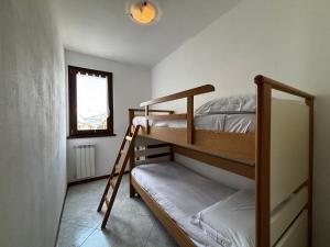 a bedroom with two bunk beds and a ladder at Alloggio Pradella - Larihome A97 in Gravedona