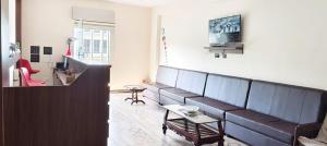 a living room with a couch and a table at Hotel Pergola - Mysore in Chāmundi