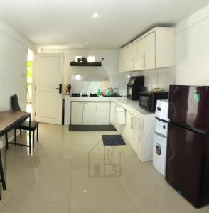 a kitchen with white cabinets and a black refrigerator at Hale lua Villa near Sanur Port in Sanur +20 photos