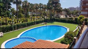 a large swimming pool in a yard with palm trees at Atico LUXURY Magic World in Oropesa del Mar