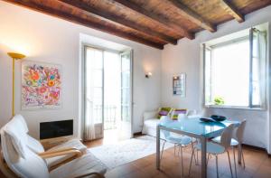 a living room with a blue table and white chairs at Villa Lina in Lezzeno