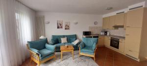 un soggiorno con un divano, sedie e un tavolo di Kranich - Ferienwohnung mit Terrasse a Dewichow