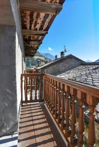 un balcone con ringhiera in legno su una casa di Maison Cupido a Saint-Rhémy-en-bosses