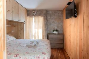 una camera da letto con un letto e una TV a parete di Maison Cupido a Saint-Rhémy-en-bosses
