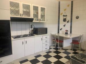 Una cocina con gabinetes blancos y piso a cuadros. en The Napping Nook, en Ciudad del Cabo