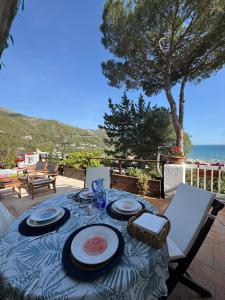 a table with plates and wine glasses on a patio at Villa Fiorella in Sperlonga