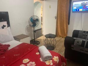 1 dormitorio con 1 cama, ventilador y TV en The Napping Nook, en Ciudad del Cabo 2 fotos más