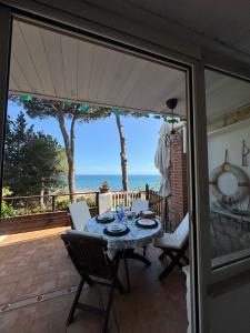 a table and chairs on a patio with a view of the ocean at Villa Fiorella in Sperlonga