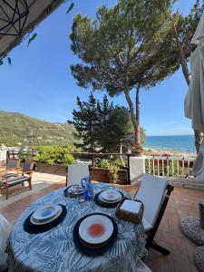 a table on a patio with a view of the ocean at Villa Fiorella in Sperlonga