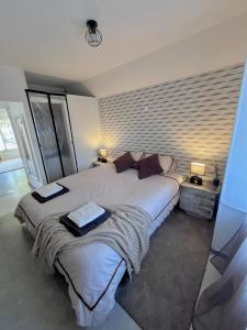 a bedroom with a large bed with two towels on it at Logement cosy & atypique à l'étage d'une maison, entrée indépendante, proche de Paris in Bonneuil-sur-Marne