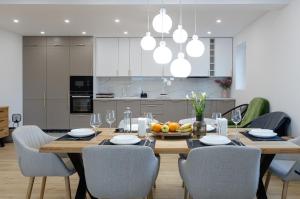 a kitchen and dining room with a wooden table and chairs at Amavi Homes With Garden in Alba Iulia
