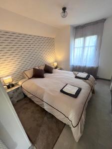 a large bed in a bedroom with a brick wall at Logement cosy & atypique, proche de Paris in Bonneuil-sur-Marne