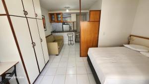 a small room with a bed and a kitchen at GuarapariResidence in Guarapari