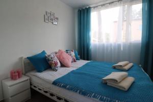 a bedroom with a bed with pillows and a window at Paradiso Park in Pobierowo