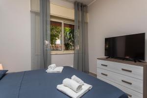 a bedroom with a tv and towels on a bed at Holiday Home Castello in Aci Castello