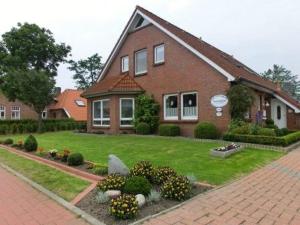 una gran casa de ladrillo con un jardín delante de ella en Haus Wiesengrund, en Werdum