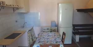 eine Küche mit einem Tisch und einem weißen Kühlschrank in der Unterkunft Quattro stagioni appartamento Inverno in Castiglione del Lago